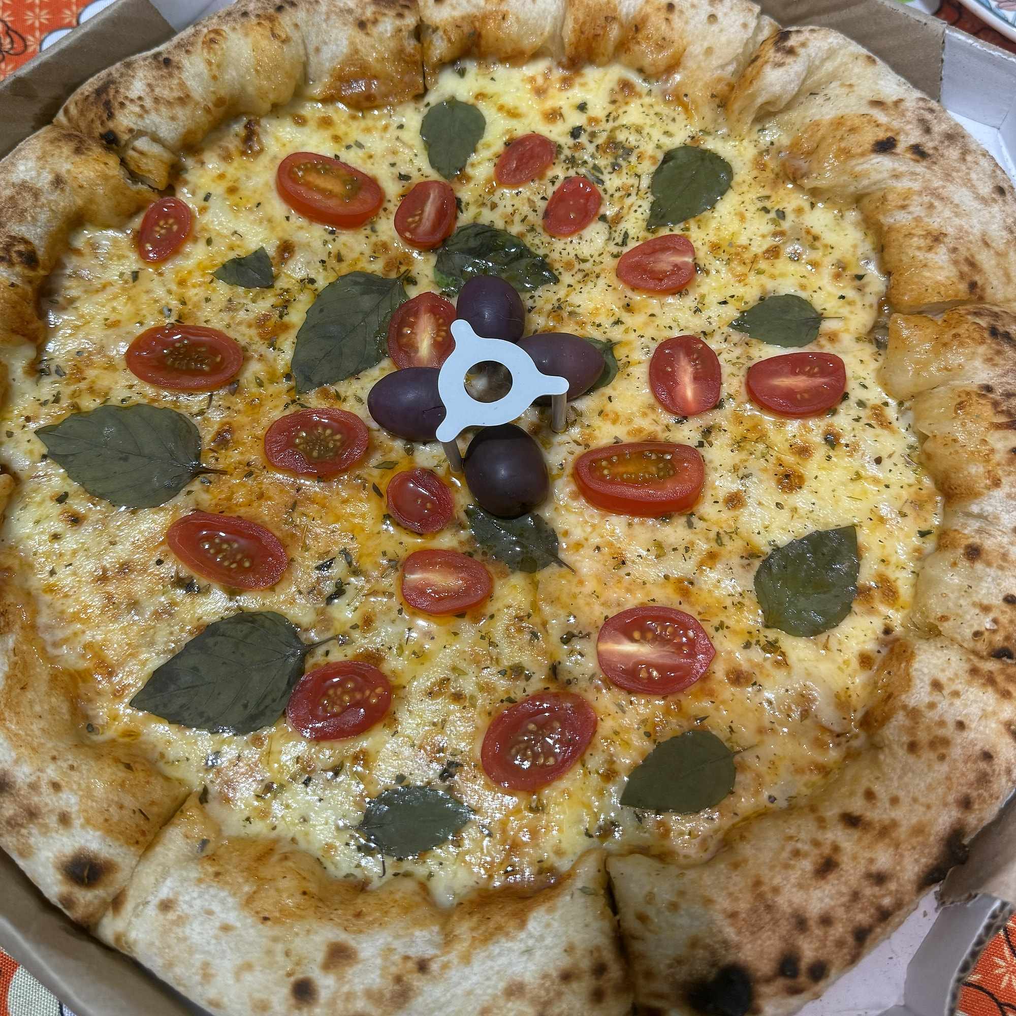 Pizza margherita da La Fratelli, com a borda alta e tostada em primeiro plano